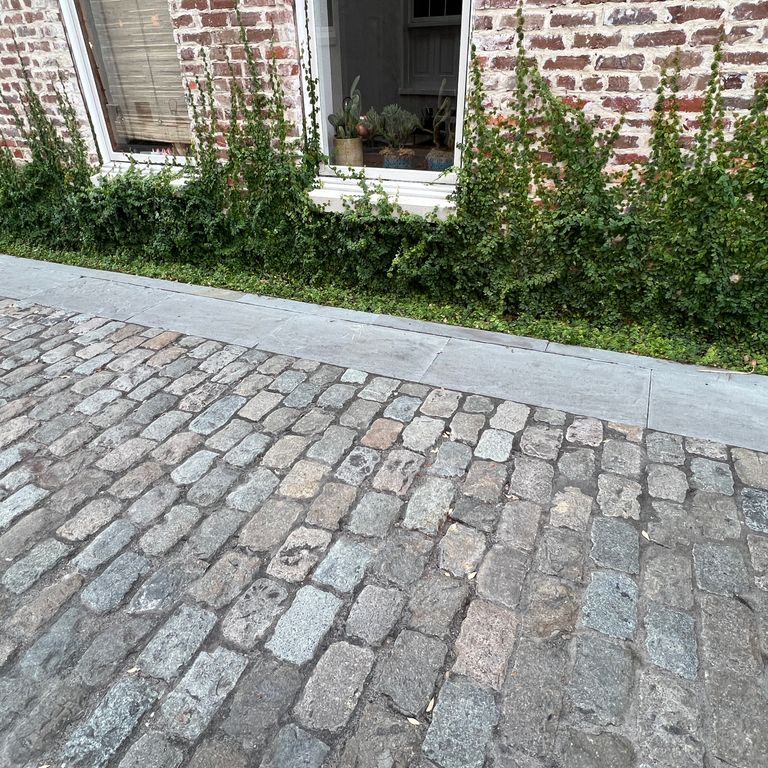Application image for Reclaimed European Porphyry Cobblestones - Rectangle - Worn. The image shows this product being used in a path pavers application. The surface finish shown is . The dominant color shown is gray.