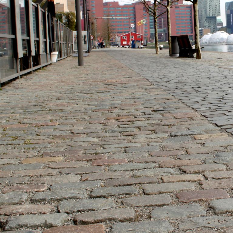 Application image for Reclaimed European Porphyry Cobblestones - Rectangle - Worn. The image shows this product being used in a public area application. The surface finish shown is . Dominant colors shown are brown and gray. The color mix creates a warm feeling.