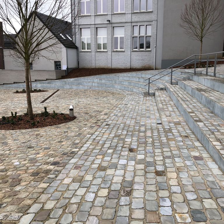 Application image for Sandstone - Reclaimed European Cobblestones - Rectangle - Flat Surface. The image shows this product being used for patio pavers and public area. The surface finish shown is sawn. The dominant color shown is gray. The color mix creates a warm feeling.
