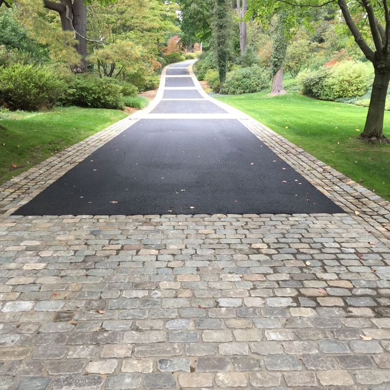 Application image for Reclaimed European Sandstone Cobblestones - Rectangle - Worn Surface. The image shows this product being used in a driveway pavers application. The surface finish shown is . The dominant color shown is gray. The color mix creates a warm feeling.