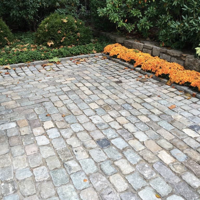 Application image for Reclaimed European Sandstone Cobblestones - Rectangle - Worn Surface. The image shows this product being used in a driveway pavers application. The surface finish shown is . The dominant color shown is gray. The color mix creates a warm feeling.