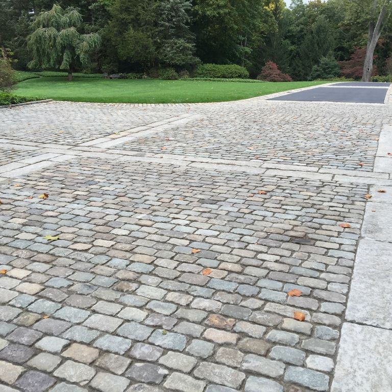 Application image for Reclaimed European Sandstone Cobblestones - Rectangle - Worn Surface. The image shows this product being used in a driveway pavers application. The surface finish shown is . The dominant color shown is gray. The color mix creates a warm feeling.