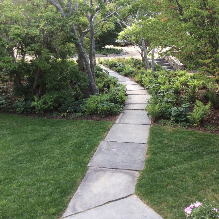 Feature image for Reclaimed Bluestone Sidewalk Stones. The image shows this product being used in a path pavers application. The surface finish shown is natural cleft. Dominant colors shown are gray, pink and white; with beige and white secondaries. The color mix creates a cool feeling. Regular color pattern.