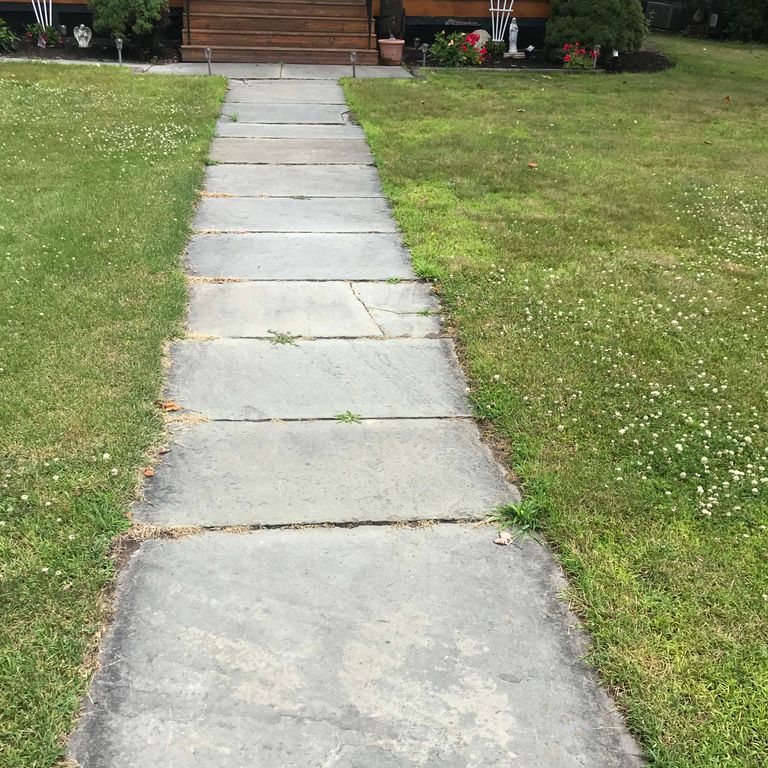 Application image for Reclaimed Bluestone Sidewalk Stones. The image shows this product being used in a path pavers application. The surface finish shown is natural cleft. The dominant color shown is gray.