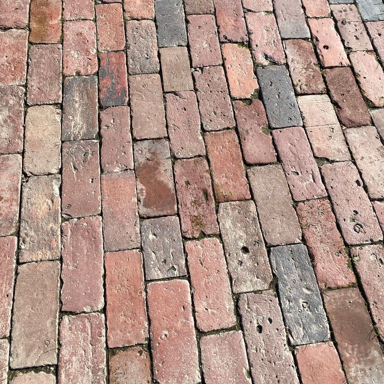Application image for Reclaimed Boston Brick Pavers. The image shows this product being used for driveway pavers, path pavers, patio pavers and driveway aprons. Dominant colors shown are gray, pink and red. The color mix creates a warm feeling. Regular color pattern.