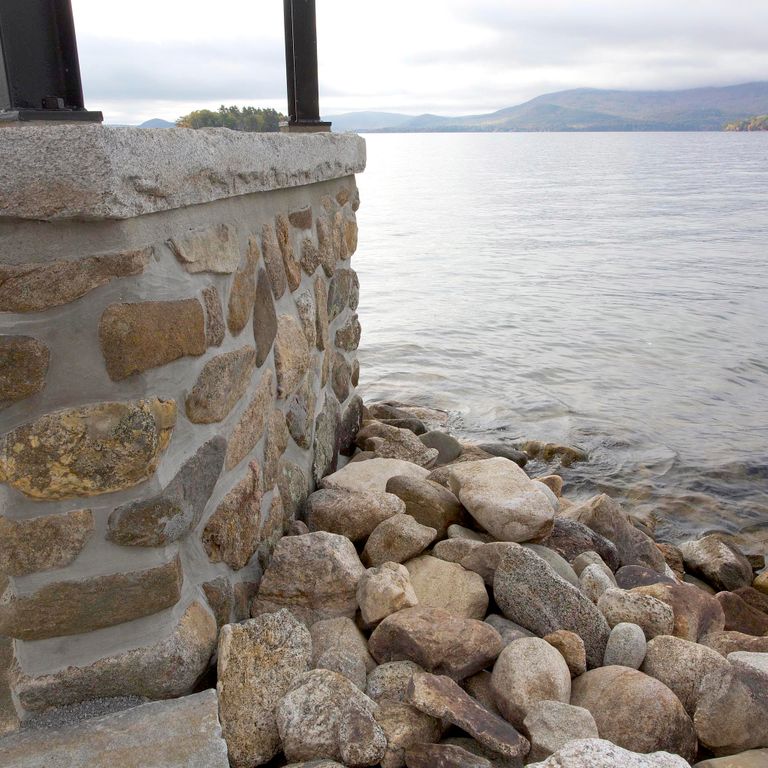 Application image for Reclaimed Granite Capstones. The image shows this product being used in a wallstone cap application. This is a landscape stone for outdoor commercial and residential applications. Suitable for general use, freeze-thaw conditions and low heat absorption surfaces situations. Moderate to higher on the price spectrum.