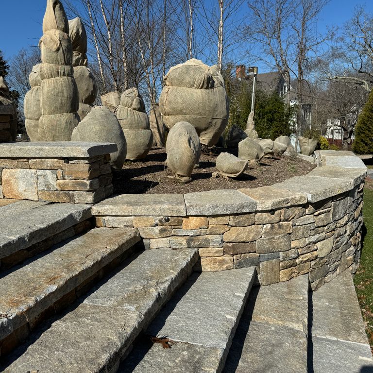 Application image for Reclaimed Granite Capstones. The image shows this product being used in a wallstone cap application. Dominant colors shown are beige and gray.