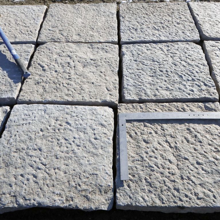 Best close-up image for Reclaimed Granite Pavers - Squares - Footworn Surface. The surface finish shown is . Dominant colors shown are beige, gray and tan; with gray and cream secondaries. The color mix creates a warm feeling. Regular, fine speckled and speckled color patterns.