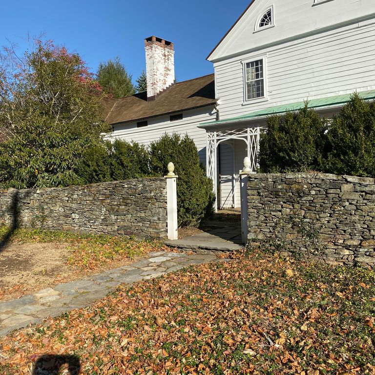 Application image for New England Fieldstone Flats - Wallstone. The image shows this product being used in a landscape wallstone application. The surface finish shown is weathered. The dominant color shown is gray. The color mix creates a warm feeling.