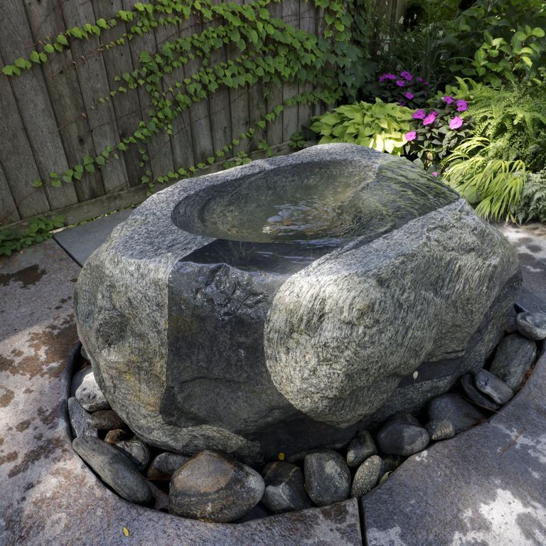 Application image for New England Fieldstone Boulders & Ledgestone - Fountains & Lights. The image shows this product being used for water features and garden accents. The surface finish shown is weathered. The dominant color shown is gray.