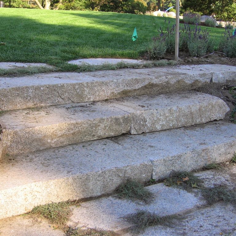 Application image for Reclaimed Granite Step - Live Edge. The image shows this product being used in a monolithic steps application. This is a landscape stone for outdoor commercial and residential applications. Suitable for general use, freeze-thaw conditions, low heat absorption surfaces, high traffic areas and low slipperiness surfaces situations. Higher to high on the price spectrum.