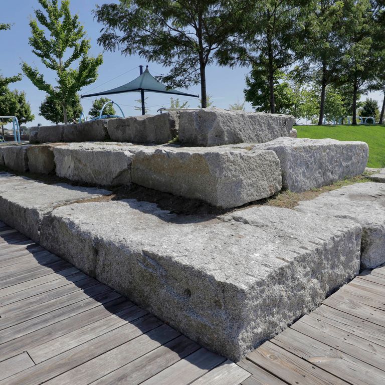 Application image for Reclaimed Granite Bridge Blocks - Benches and Seating. The image shows this product being used in a seating & benches application. This is a landscape stone for outdoor commercial and residential applications. Suitable for general use, freeze-thaw conditions, low heat absorption surfaces and low slipperiness surfaces situations. Relatively higher in price.