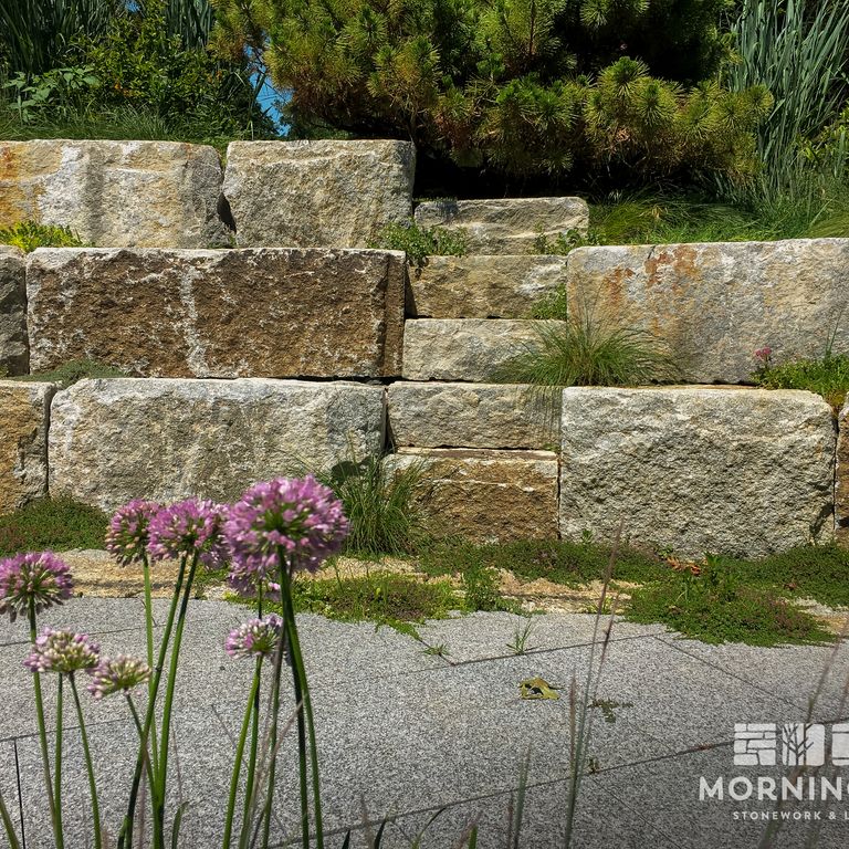 Application image for Reclaimed Granite Bridge Blocks - Benches and Seating. The image shows this product being used in a seating & benches application. This is a landscape stone for outdoor commercial and residential applications. Suitable for general use, freeze-thaw conditions, low heat absorption surfaces and low slipperiness surfaces situations. Relatively higher in price.