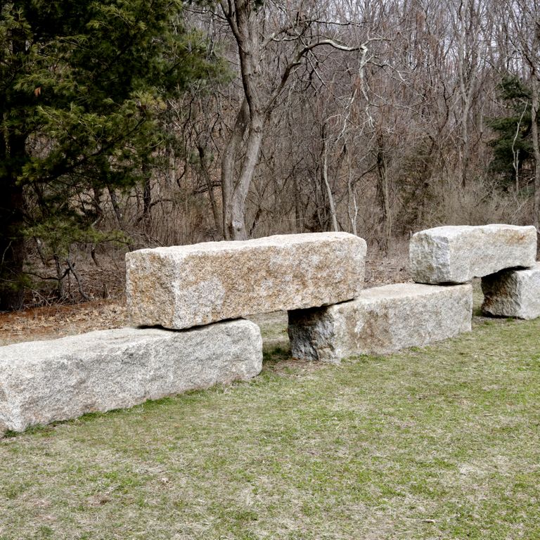 Application image for Reclaimed Granite Bridge Blocks - Benches and Seating. The image shows this product being used for garden accents and seating & benches. The surface finish shown is . The dominant color shown is gray. The color mix creates a warm feeling. Fine speckled color pattern.