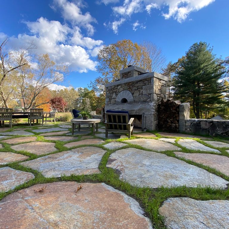 Feature image for Goshen Stone - Irregular Flagstone. The image shows this product being used in a patio pavers application. Dominant colors shown are brown, gray and tan; with beige, orange/rust, purple, white and cream secondaries. Exhibits 