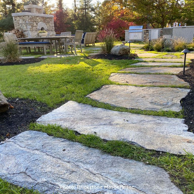 Application image for Goshen Stone - Irregular Flagstone. The image shows this product being used in a path pavers application. The surface finish shown is split-face with flat plane. The dominant color shown is gray; with beige, black, blue, brown, orange/rust, purple, white and tan secondaries. The color mix creates a warm feeling. Random color pattern. Contains lots of mica and mineral inclusions.