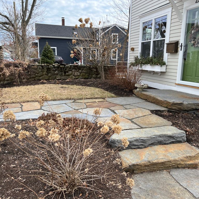 Application image for Goshen Stone - Irregular Flagstone. The image shows this product being used for path pavers and monolithic steps. The surface finish shown is split-face. Dominant colors shown are brown, gray and orange/rust. The color mix creates a warm feeling. Regular and blotched color patterns. Contains lots of mica and mineral inclusions.