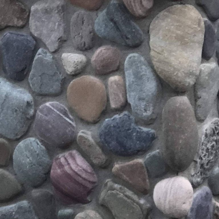Close-up image for River Rounds Veneer. The surface finishes shown are natural and worn. The dominant color shown is gray; with black, blue, brown, green, purple and white secondaries. Exhibits 