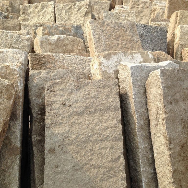 Close-up image for Reclaimed Granite Rustic Plank Pavers. The surface finish shown is split-face with rough plane. Dominant colors shown are beige, brown and tan; with gray, orange/rust and cream secondaries. The color mix creates a warm feeling. Regular, speckled and blotched color patterns.