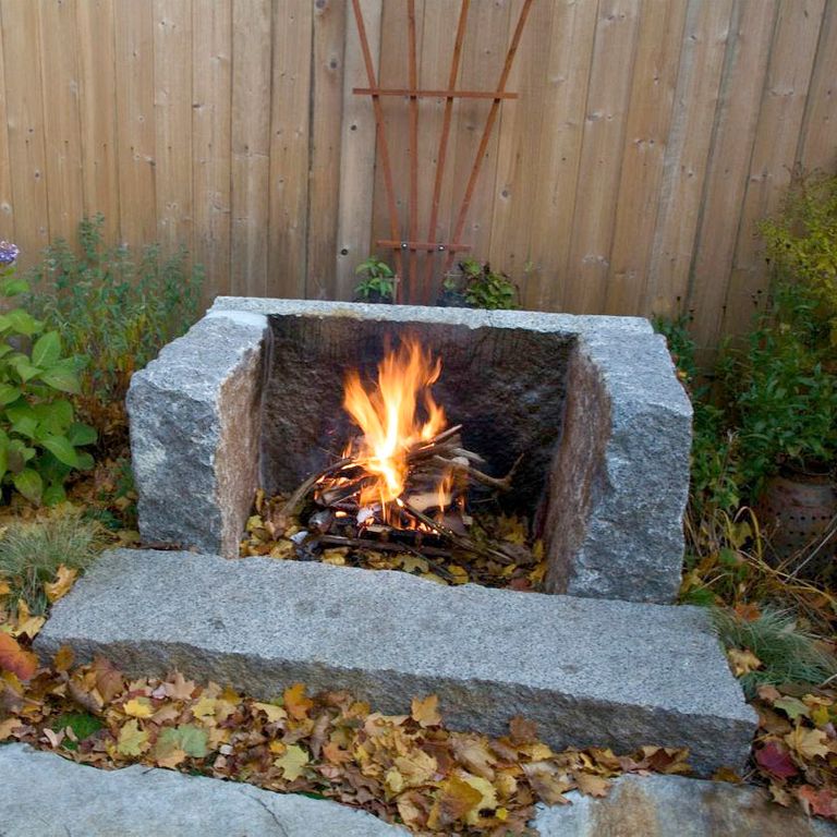Best close-up image for Reclaimed Granite Fire Feature - Hearth, Mantel, Surround. The image shows this product being used in an outdoor fire concepts application. The surface finish shown is split-face. The dominant color shown is gray. Exhibits 