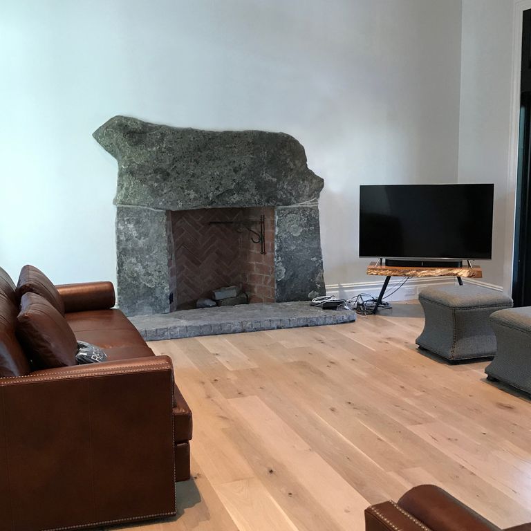 Application image for Reclaimed Granite Fire Feature. The image shows this product being used for fireplace hearth and fireplace surround. This is a building and landscape stone for indoor and outdoor residential applications. Suitable for general use situations. Higher to high on the price spectrum.