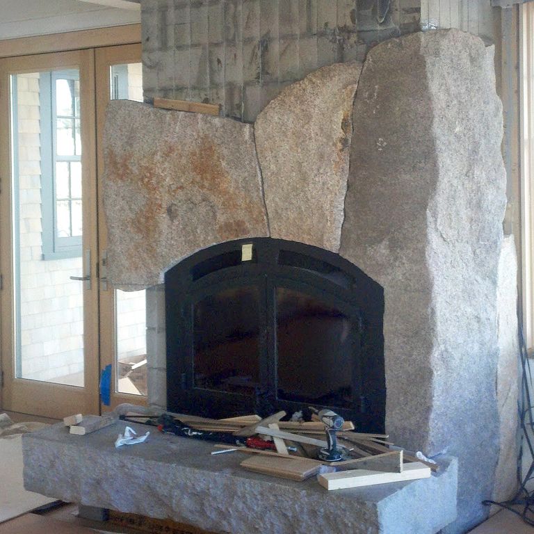 Application image for Reclaimed Granite Fire Feature. The image shows this product being used for fireplace hearth and fireplace surround. This is a building and landscape stone for indoor and outdoor residential applications. Suitable for general use situations. Higher to high on the price spectrum.