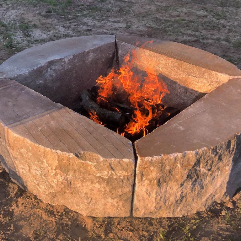 Best close-up image for Reclaimed D-Radius Curbstone Fire Pit. The image shows this product being used in an outdoor fire concepts application. The surface finish shown is a combination of weathered and worn. The dominant color shown is gray; with brown and tan secondaries. The color mix creates a cool feeling. Speckled and blotched color patterns.
