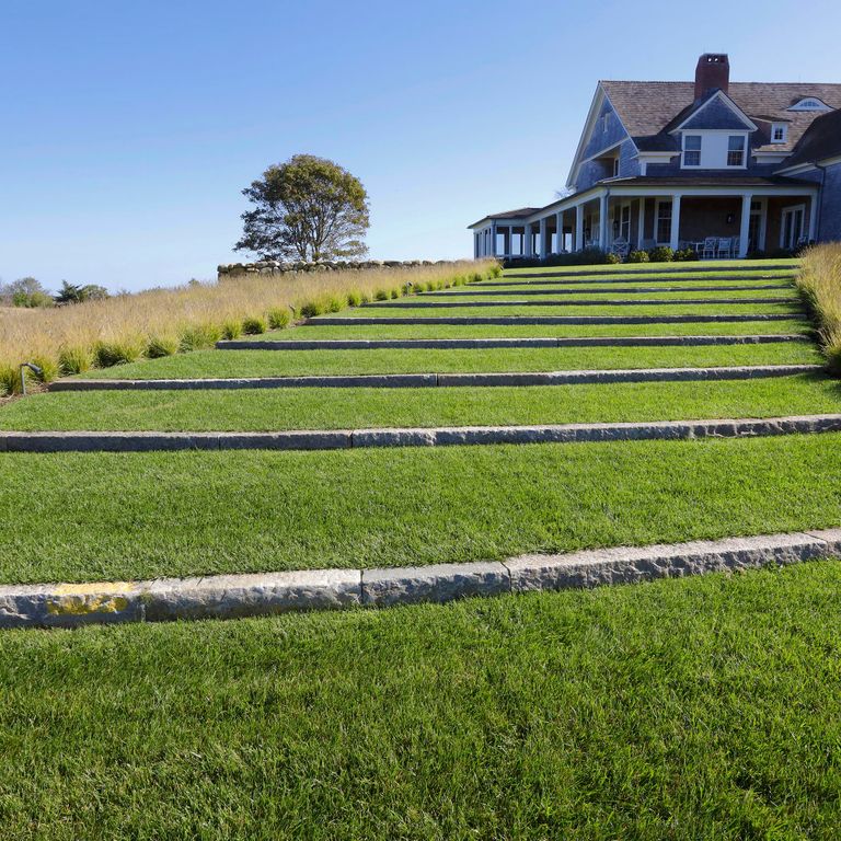 Feature image for Reclaimed First Generation Granite Curbstone - Lawn Steps. The image shows this product being used for landscape curbing & edging and monolithic steps. The surface finish shown is . The dominant color shown is gray; with brown and tan secondaries. The color mix creates a cool feeling. Speckled color pattern.