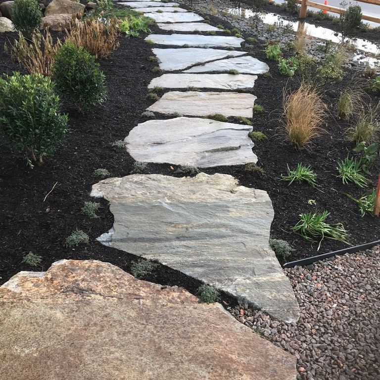Application image for Granite - Black Mountain - Oversized Irregular Pavers - Natural top. The image shows this product being used in a path pavers application. Dominant colors shown are brown, gray and tan. The color mix creates a warm feeling.