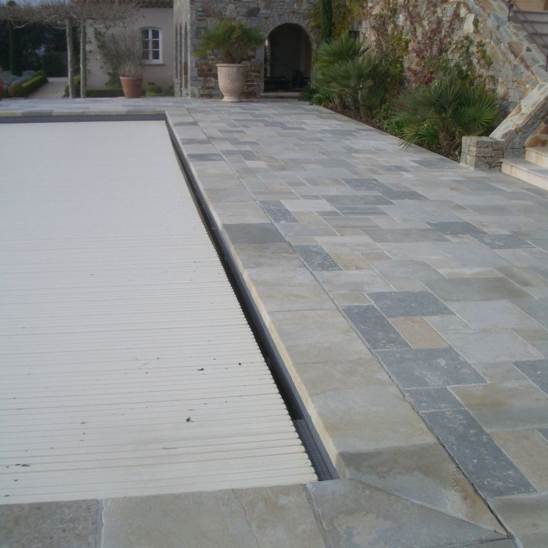 Feature image for Limestone- Mixed Blend -  Pool Coping. The image shows this product being used for pool coping and pool deck pavers. The dominant color shown is gray; with beige, blue, brown, green and white secondaries. Exhibits 