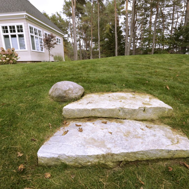 Application image for White Mountain Granite - Live Edge Steps. The image shows this product being used in a monolithic steps application. This is a landscape stone for outdoor commercial and residential applications. Suitable for general use, freeze-thaw conditions, low heat absorption surfaces, high traffic areas, low slipperiness surfaces and high heel compatibilty situations. Moderate to higher on the price spectrum.
