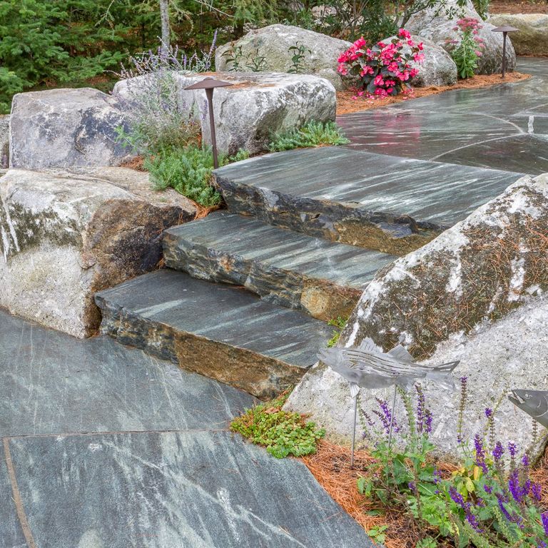 Feature image for Granite- Mystic Mountain- Steps. The image shows this product being used in a monolithic steps application. The dominant color shown is gray; with blue, brown and green secondaries. Exhibits 