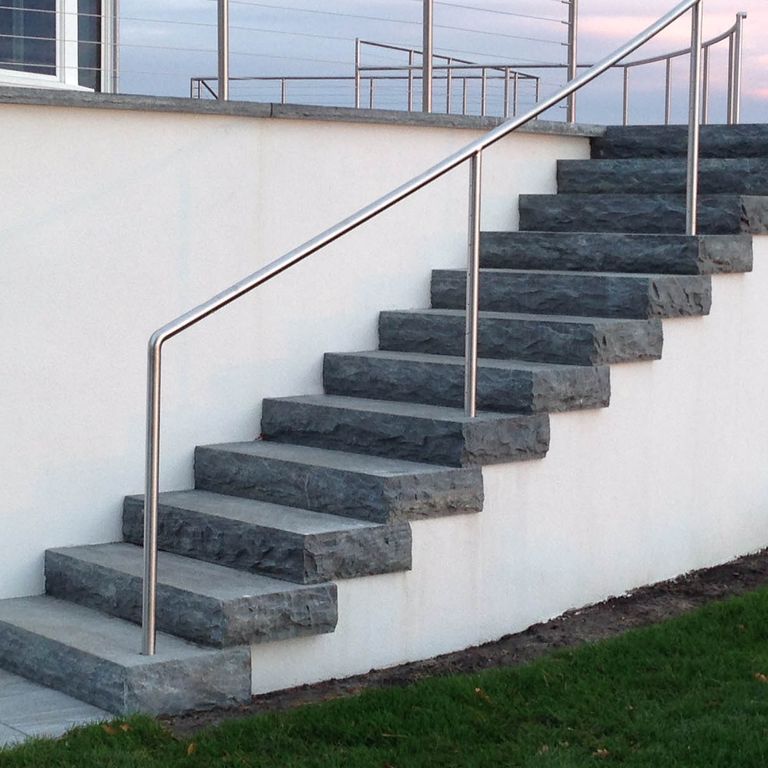 Application image for Granite- Mystic Mountain- Steps. The image shows this product being used in a monolithic steps application. This is a building and landscape stone for indoor and outdoor commercial and residential applications. Suitable for general use, freeze-thaw conditions, high traffic areas, low slipperiness surfaces and high heel compatibilty situations. Higher to high on the price spectrum.