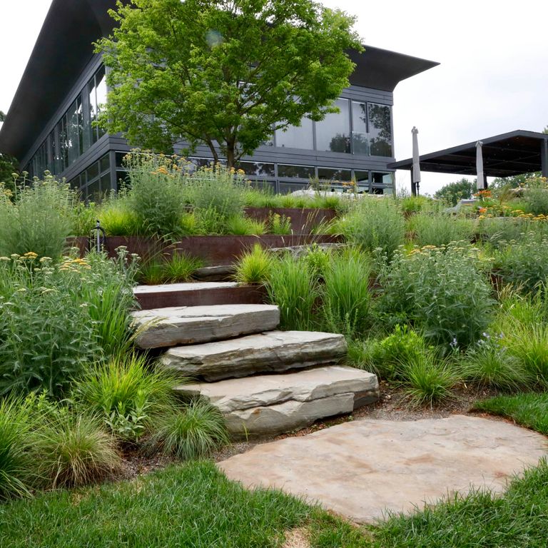 Feature image for Mystic Mountain Natural - Steps & Landings. The image shows this product being used for landings and monolithic steps. Dominant colors shown are beige and gray; with brown, orange/rust, white and tan secondaries. Exhibits 