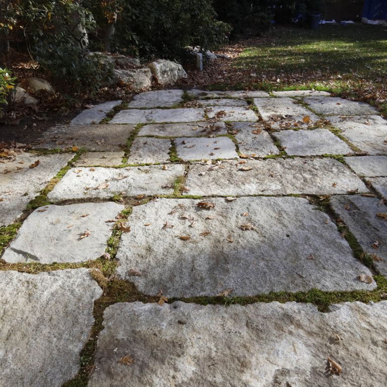 Application image for Reclaimed Granite Block - Quarry Skin Pavers. The image shows this product being used in a patio pavers application. The surface finish shown is . The dominant color shown is gray. The color mix creates a warm feeling. Blotched color pattern.