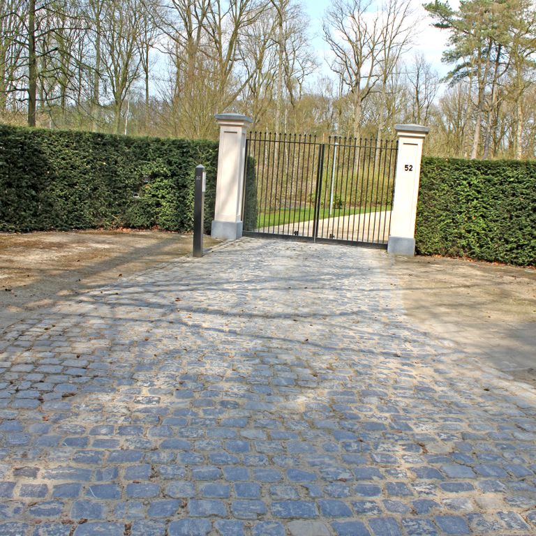 Application image for Reclaimed Belgian Bluestone Cobblestones - Worn Surface. The image shows this product being used in a driveway pavers application. The surface finish shown is . Dominant colors shown are blue and gray. The color mix creates a warm feeling.