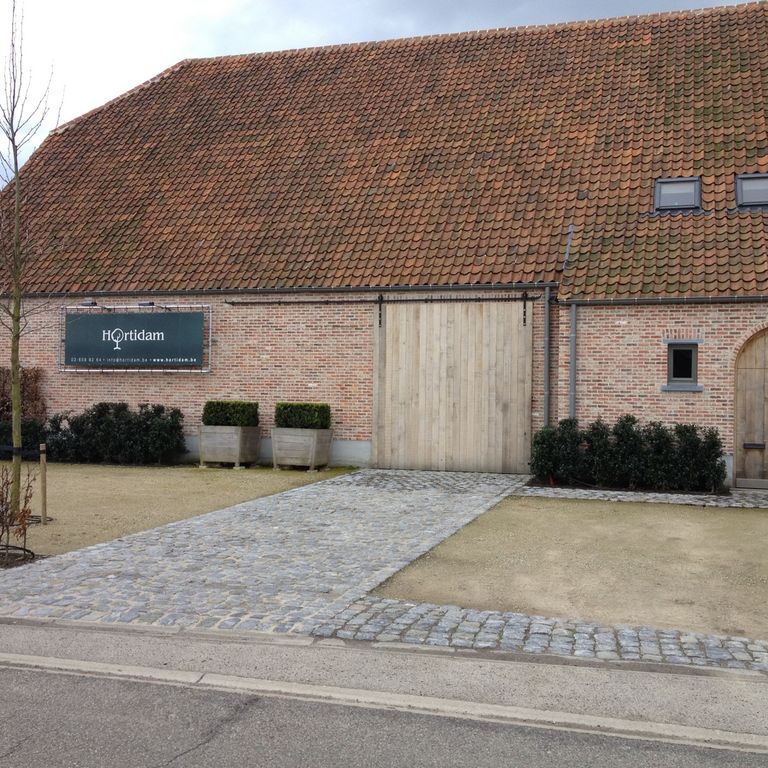 Application image for Reclaimed Belgian Bluestone Cobblestones - Worn Surface. The image shows this product being used in a driveway pavers application. The surface finish shown is . The dominant color shown is gray. The color mix creates a warm feeling.