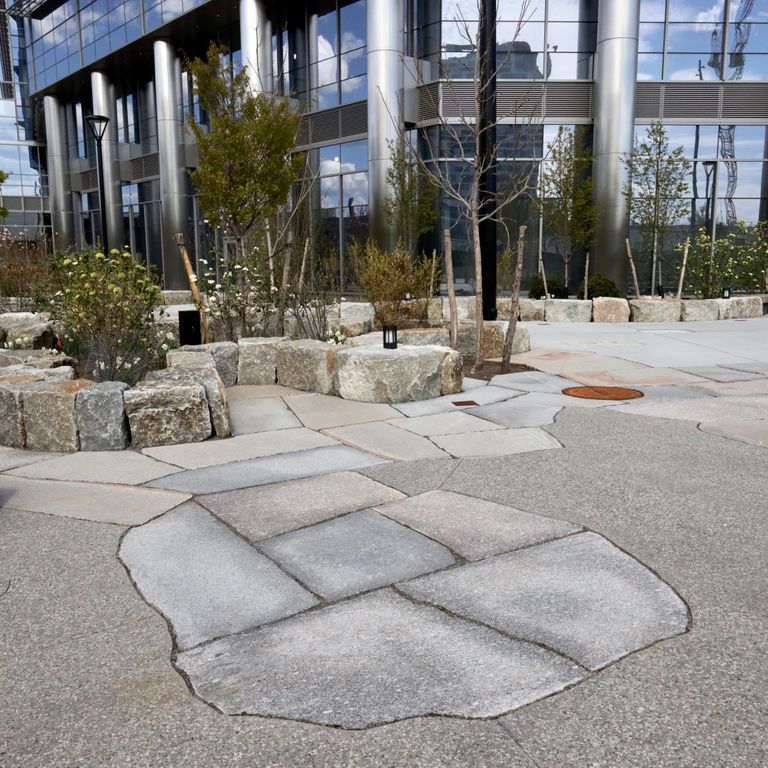 Application image for Granite - New England Mix - Live Edge Paver. The image shows this product being used for patio pavers and public area. The dominant color shown is gray. The color mix creates a cool feeling.