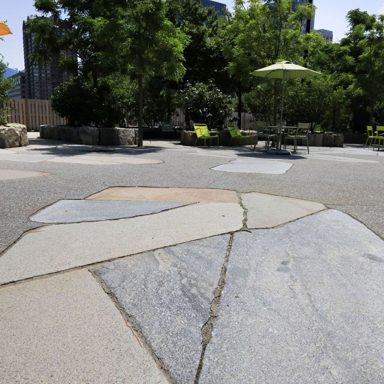 Application image for Granite - New England Mix - Live Edge Paver. The image shows this product being used for patio pavers and public area. The surface finish shown is flamed. The dominant color shown is gray. The color mix creates a cool feeling. Fine speckled, speckled and random color patterns.