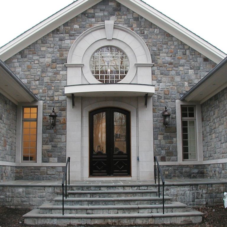 Feature image for Adirondack Granite - Veneer. The image shows this product being used in a window well application. The dominant color shown is gray; with beige, blue, brown, green, purple and white secondaries. Speckled color pattern.