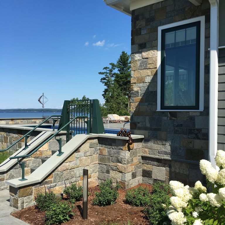 Application image for American Mist Granite - Pavers. The image shows this product being used in a landscape wallstone application. The color mix creates a warm feeling.
