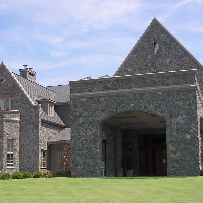 Feature image for Blue Mountain Granite - Veneer. The image shows this product being used in a full bed veneer application. The dominant color shown is gray; with black, brown and purple secondaries. Exhibits 