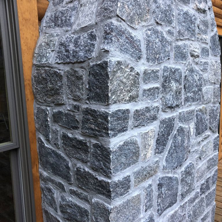 Feature image for Heritage Granite - Wall Veneer. The image shows this product being used in a full bed veneer application. Dominant colors shown are blue and gray; with black, brown, purple and cream secondaries. The color mix creates a cool feeling. Regular, speckled, blotched and cloudy color patterns.