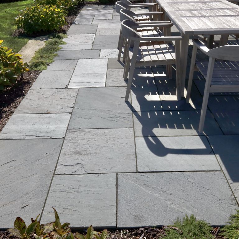 Application image for Bluestone Natural Cleft Blue/Gray - Dimensional Cut Pavers. The image shows this product being used in a patio pavers application. The surface finish shown is natural cleft. The dominant color shown is gray; with a blue secondary. The color mix creates a cool feeling. Solid color pattern.