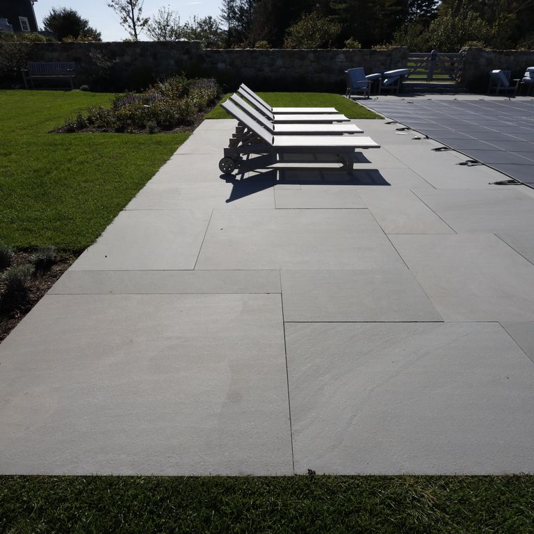 Application image for Bluestone Flamed Surface Blue/Gray - Dimensional Cut Pavers. The image shows this product being used in a pool deck pavers application. The surface finish shown is flamed. The dominant color shown is gray; with a blue secondary. The color mix creates a cool feeling. Solid color pattern.