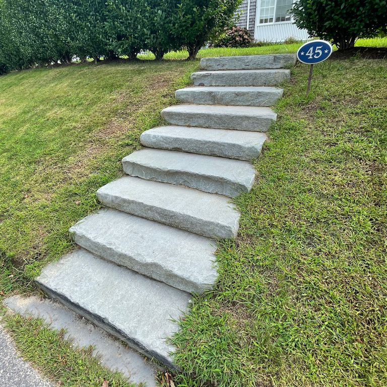 Application image for Bluestone Flamed Surface Blue/Gray - Tumbled Pavers. The image shows this product being used in a monolithic steps application. The surface finish shown is tumbled. The dominant color shown is gray; with blue and white secondaries. The color mix creates a cool feeling.