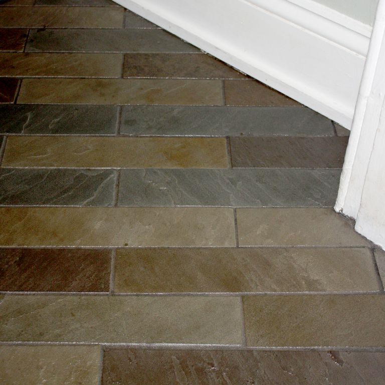 Feature image for Bluestone Natural Cleft Burgundy/Brown - Interior Flooring. The image shows this product being used in an interior floor application. The dominant color shown is brown; with green, gray, purple and tan secondaries. Exhibits 