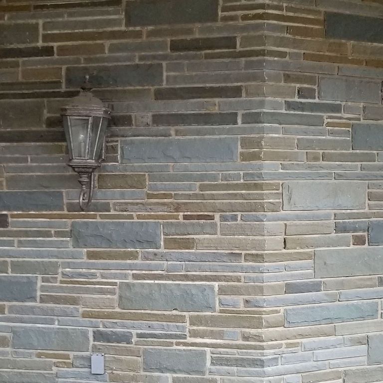 Close-up image for Bluestone Flamed Surface Full Color - Full Bed Veneer. The surface finish shown is split-face with rough plane. Dominant colors shown are gray and tan; with beige, blue, brown, green, purple and white secondaries. Exhibits 