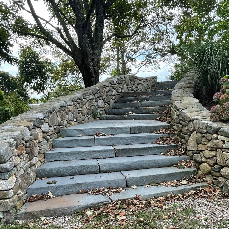 Application image for Bluestone Flamed Surface Blue/Gray - Monolithic Steps. The image shows this product being used in a monolithic steps application. The surface finish shown is flamed. Dominant colors shown are blue and gray. The color mix creates a cool feeling. Solid color pattern.