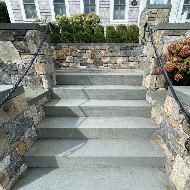 Application image for Bluestone Flamed Surface Blue/Gray - Monolithic Steps. The image shows this product being used in a monolithic steps application. The surface finish shown is flamed. The dominant color shown is gray; with blue and white secondaries. The color mix creates a warm feeling. Solid color pattern.